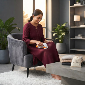 A woman using a lint remover on a woolen kurta in a modern living room setting.